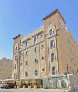 a large brick building with a car parked in front of it at RJ's - Beautiful 3 Bedroom Apartment in Al Khobar