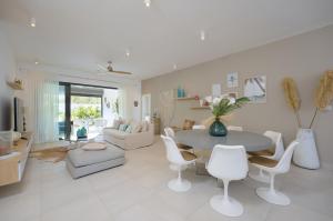 un salon blanc avec une table et des chaises dans l'établissement Pointe aux Canonniers Beach Luxury Apartment, à Pointe aux Cannoniers