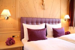 a bedroom with a bed with purple and white pillows at Appartamenti Loretta in La Villa