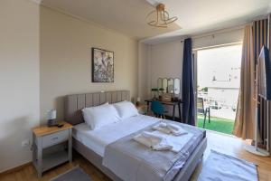 a bedroom with a bed with a table and a window at AIOLOS elegant escapes GLYFADA apartment in Athens