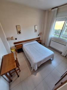 a bedroom with a bed and a table and a window at Hotel Berna in La Rúa
