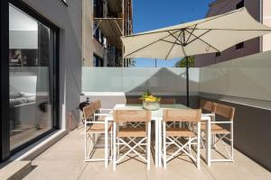 a table and chairs with an umbrella on a balcony at Casa Cocooon in Funtana