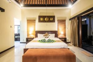 a bedroom with a large bed and two lamps at 6-BR Private Pool Samudra Villa Tiga Umalas 10min to Canggu Beach in Umalas +50 photos