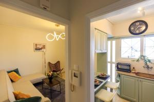a living room with a couch and a clock on the wall at AIOLOS elegant escapes GLYFADA apartment in Athens