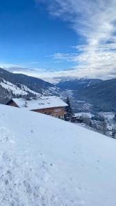 a snow covered hill with a building in the distance at Hotel Almhof in San Candido