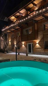 a building with a pool in front of it at night at Hotel Almhof in San Candido
