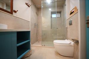 ジャイプールにあるThe Bodhi 5 Bedroom LuxuryApartment Central Jaipurのトイレとガラスのシャワー付きのバスルーム