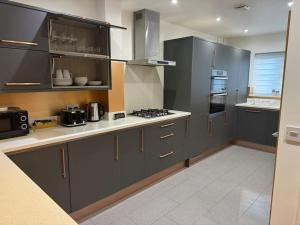 a kitchen with gray cabinets and a stove top oven at Windsor and slough in Slough