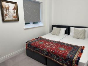 a bedroom with a bed with a red blanket on it at Windsor and slough in Slough