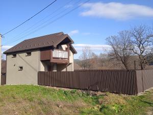 a house with a fence in front of it at Галерея Карпат in Mykulychyn