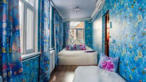 a blue room with a bed and a window at Guest House Vostryakovo in Domodedovo
