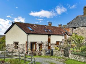 an old stone house with a brown roof at Lane End Cottage North Molton in North Molton