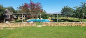 a house with a swimming pool and a stone wall at Riverbank in Tulbagh