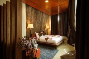 a bedroom with a bed and a table with flowers at Nangyuan Island Dive Resort in Ko Tao
