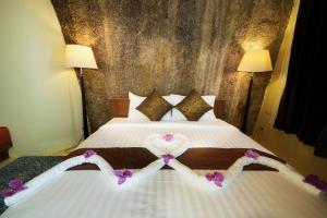 a bedroom with a bed with purple flowers on it at Nangyuan Island Dive Resort in Ko Tao
