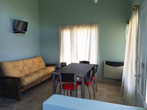una sala de estar con una mesa y un sofá en Altos de Ayelen, en Esquel