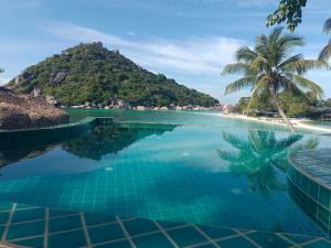 a pool with a view of a beach and a mountain at Nangyuan Island Dive Resort in Ko Tao
