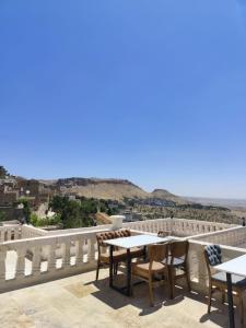 a balcony with tables and chairs and a view of the ocean at Rumetpaşakonağı in Mardin +58 photos