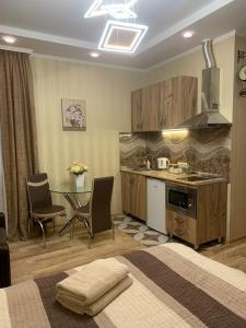 a kitchen with a bed and a table with chairs at Beautiful Tbilisi on Meskhishvili Turn in Tbilisi City