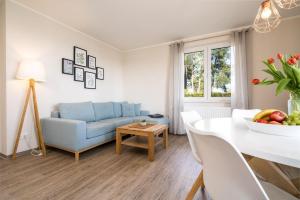 a living room with a blue couch and a table at Strandhaus-1-EG in Marienfelde