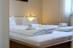 two beds with white sheets and towels on them at Strandhaus-1-EG in Marienfelde
