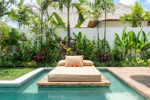 een bed naast een zwembad bij Villa Lounes 1 - Walking Distance to Nyanyi Beach in Tanah Lot +71 foto's