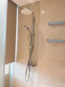 une douche avec pommeau de douche dans une salle de bain dans l'établissement Condotel Arena Beach Near the Airport, à Thôn Hòa Ða