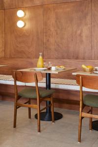 a table and chairs in a room with a bench at Hotel des Victoires - Restaurant in Cannes
