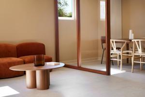 a living room with a mirror and a table at Hotel des Victoires - Restaurant in Cannes