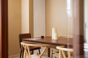 a dining room with a wooden table and chairs at Hotel des Victoires - Restaurant in Cannes