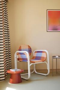 a chair and a table in a room at Hotel des Victoires - Restaurant in Cannes