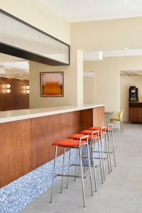 a row of orange stools at a bar at Hotel des Victoires - Restaurant in Cannes