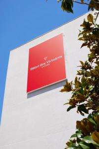 a red sign on the side of a building at Hotel des Victoires - Restaurant in Cannes