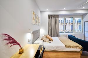 a bedroom with a bed and a desk and a window at Apartamentos Esperanza by gaiarooms in Salamanca