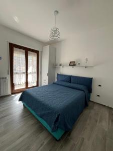 - une chambre avec un lit bleu et du parquet dans l'établissement Gassa d Amante Borghetto Santo Spirito, à Borghetto Santo Spirito
