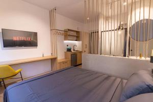 ein Schlafzimmer mit einem Bett und einem gelben Stuhl in der Unterkunft MKproperties in Volos