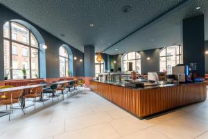 un restaurante con barra, sillas y ventanas en La Brasserie Hostel, en Metz