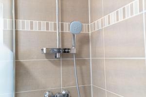 a shower with a shower head in a bathroom at Apart' MIN - Disneyland Paris - 3 Bedrooms - 2 Parking Spots in Bailly-Romainvilliers +49 photos