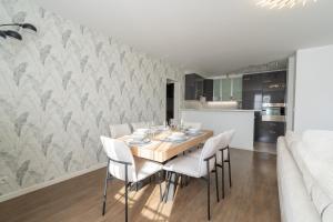 a dining room with a table and white chairs at Apart' MIN - Disneyland Paris - 3 Bedrooms - 2 Parking Spots in Bailly-Romainvilliers