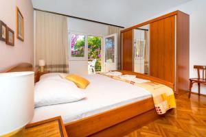 a bedroom with a large bed with a wooden headboard at Holiday House Lido in Orebić