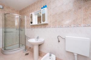 a bathroom with a sink and a shower and a toilet at Holiday House Lido in Orebić +25 photos