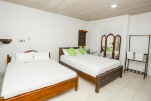 ゴールにあるThuli villa 3 bedroom villaのベッド2台と鏡のある寝室