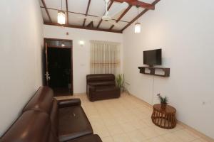 ゴールにあるThuli villa 3 bedroom villaのソファとテレビのあるリビングルーム
