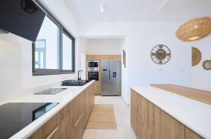 une cuisine avec des armoires en bois et un comptoir dans l'établissement Pointe aux Canonniers Beach Luxury Apartment, à Pointe aux Cannoniers 22 autres photos