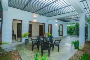 ゴールにあるThuli villa 3 bedroom villaのパティオ(パーゴラの下にテーブルと椅子付)