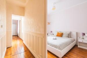 una camera bianca con un letto e un corridoio di Spacieux Cœur de Reims a Reims