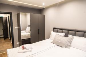 una camera da letto con un grande letto bianco e uno specchio di Liberte Apartments a Sombor