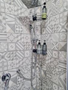baño con ducha y 2 botellas en la pared en CLALE ROOMS, en Nápoles
