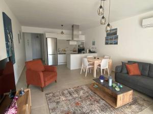 a living room with a couch and a table and a kitchen at Blue Serenity - DeJa Blue 2 - C13 in Kalogrea