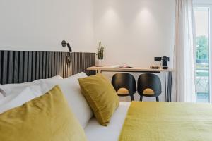a bedroom with a bed with yellow pillows and a desk at Appart Hotel Neostelia in Annecy